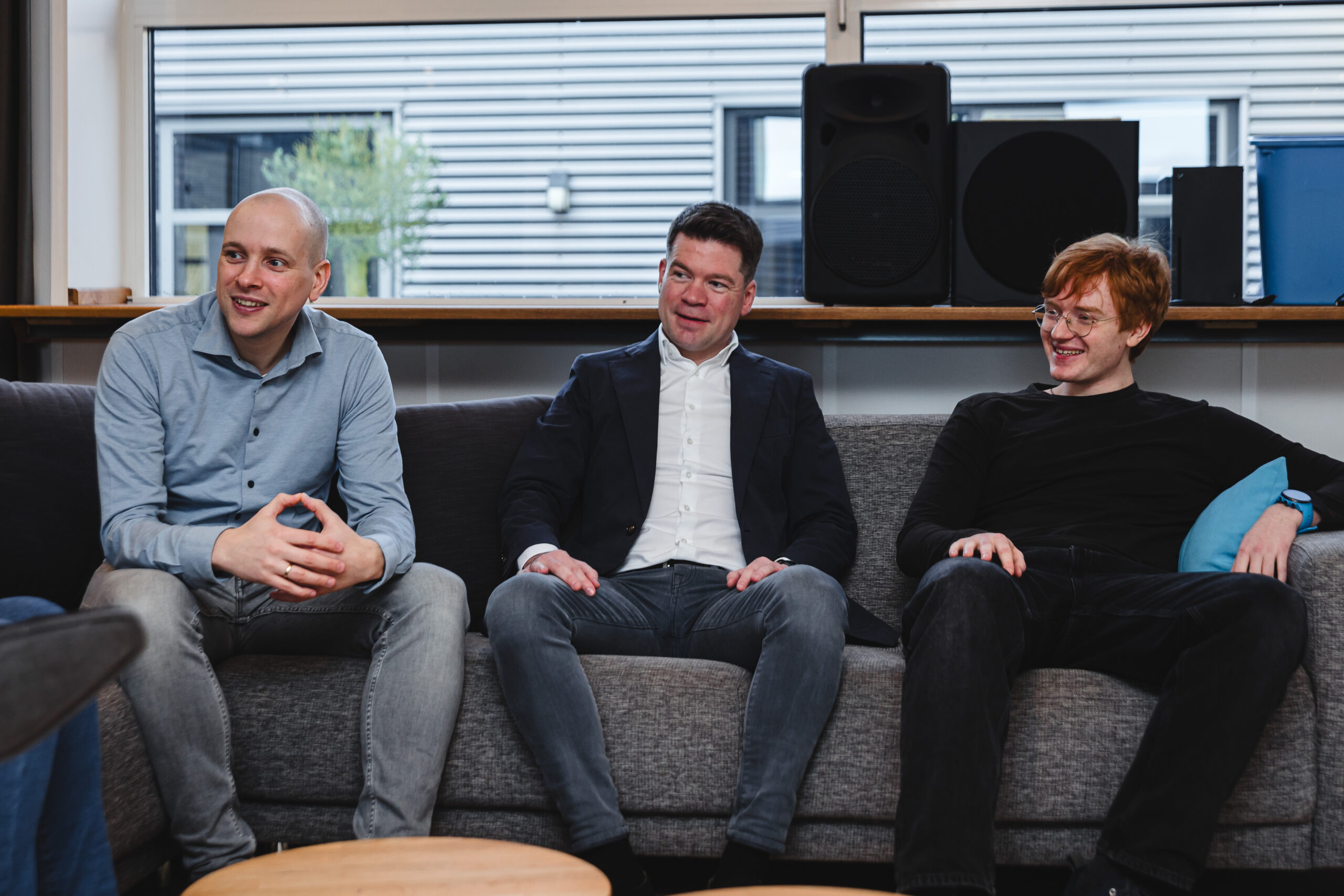 Three people sitting next to each other.