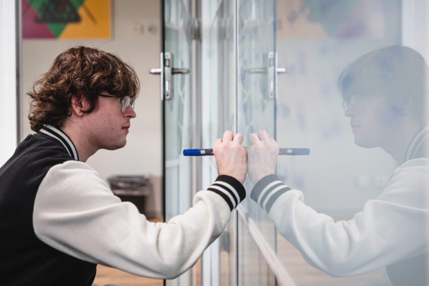Person in front of a whiteboard, writing.