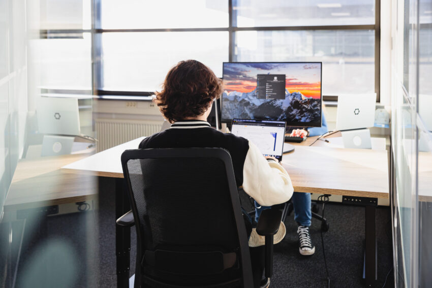 Person seen from the back behind a laptop.
