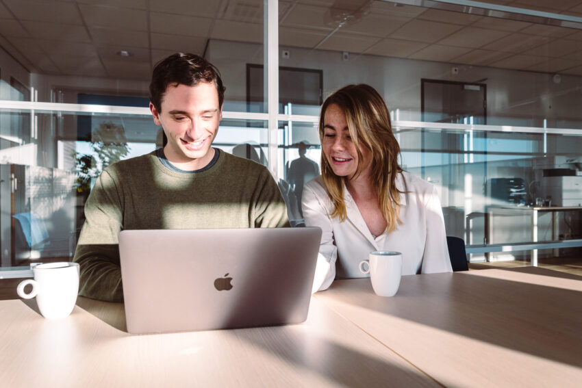 Two people behind a laptop.