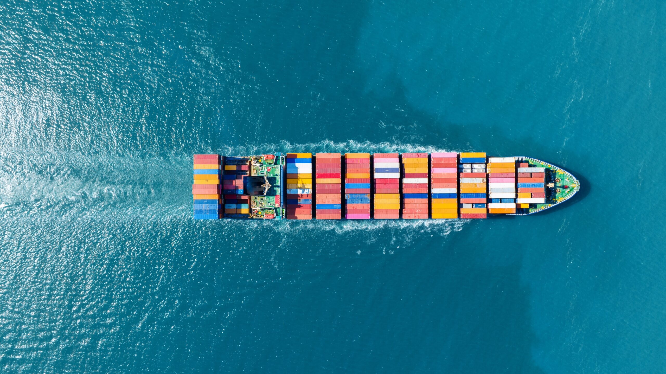 Top view of a cargo container ship in the ocean, carrying containers and operating for import/export, concept technology, freight shipping by ship.